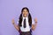 Excited happy indian school girl show thumbs up isolated on violet background.