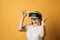 Excited happy screaming blonde woman in white t-shirt uses VR glasses exploring augmented reality holding hands up