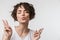 Excited happy woman posing isolated over white wall background showing peace gesture