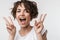 Excited happy woman posing isolated over white wall background showing peace gesture