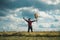 Excited hiker man with guitar looking at beautiful view. Man hipster hiker in autumn field.