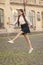 Excited about holidays. Happy child celebrate holidays outdoors. Energetic girl marching in school uniform. School