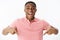 Excited and impressed happy african american man standing high pointing down with amazed and cheerful expression