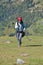 A excited Indian young male traveler smiling walking up in the mountain after finished paragliding flight