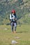 A excited Indian young male traveler smiling walking up in the mountain after finished paragliding flight