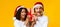 Excited interracial couple in santa hats holding Xmas gift box