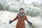 Excited joyful woman standing in falling snow for first time in life