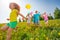 Excited kids with balloons run in field