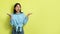 Excited Korean Female Looking Aside Advertising Offer On Yellow Background