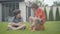 Excited little boy sitting on ball and talking with friend. Portrait of two happy Caucasian children resting outdoors on