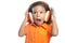 Excited little girl with an afro hairstyle enjoying her music on bright orange headphones