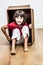 Excited little girl sitting in cardboard box playing for surprise