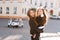 Excited long-haired girl hanging out with little sister wearing trendy black jeans and hair accessory. Portrait of