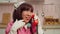 Excited lovely Asian woman in cosplay costume picking up vintage landline phone
