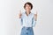 Excited lucky woman in blue collar shirt, pointing and looking up with cheerful smile, checking out company banner