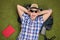 Excited male hiker lying on his backpack in a field