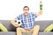 Excited male sport fan with soccer ball and beer watching sport