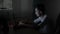 Excited male student sitting on his desk typing and chatting online with his girlfriend at night in a dark room -