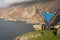 Excited male tourist with his hand up in the air enjoys stunning view of amazing scenery of Slieve League Cliff in County Donegal