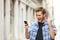 Excited man checking news on phone in the street