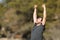 Excited man raising arms in nature