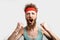 Excited man in red headband cheering for his soccer team, isolated on white.