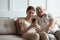Excited mature dad and adult daughter using smartphone
