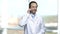 Excited mature doctor talking on cell phone.