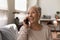 Excited mature woman making call using cell enjoy good conversation