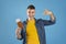 Excited millennial guy pointing at passport and airplane tickets on blue background