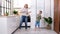 Excited mom or babysiter and kid boy jumping dancing laughing in modern scandinavian house kitchen Happy family mother