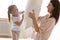 Excited mother and little daughter playing pillow fight close up