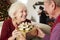 Excited Mother Receiving Christmas Gift From Daughter At Home