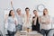 excited multicultural businesswomen standing near desk