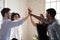 Excited multiethnic coworkers give high five engaged in teambuilding activity