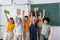 excited multiethnic schoolkids holding books in