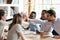 Excited multiracial team giving high five at company meeting