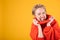 Excited naughty screaming blonde woman portrait in red jumper on vivid yellow background