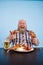 Excited obese man holds chicken leg and bunch of sausages at table in studio