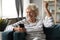 Excited older woman using phone, celebrating good new