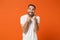 Excited overjoyed young man in casual white t-shirt posing isolated on bright orange wall background, studio portrait