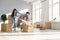 Excited parents and kids playing with cardboard boxes in their newly bought house