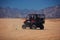 Excited people are driving a buggy car through the desert. extreme tourism adventures