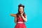 Excited pinup retro style housewife holding homemade pie, feeling excited on blue studio background