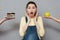 Excited pregnant woman choosing between apple and a cake