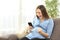 Excited pregnant woman looking at mobile phone