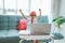 excited primary school student with uniform raise her arm during online class