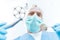 Excited professional dentist in medical mask holding dental tools