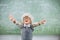 Excited schoolboy with hand spread in classroom