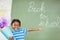 Excited schoolboy holding gift in classroom